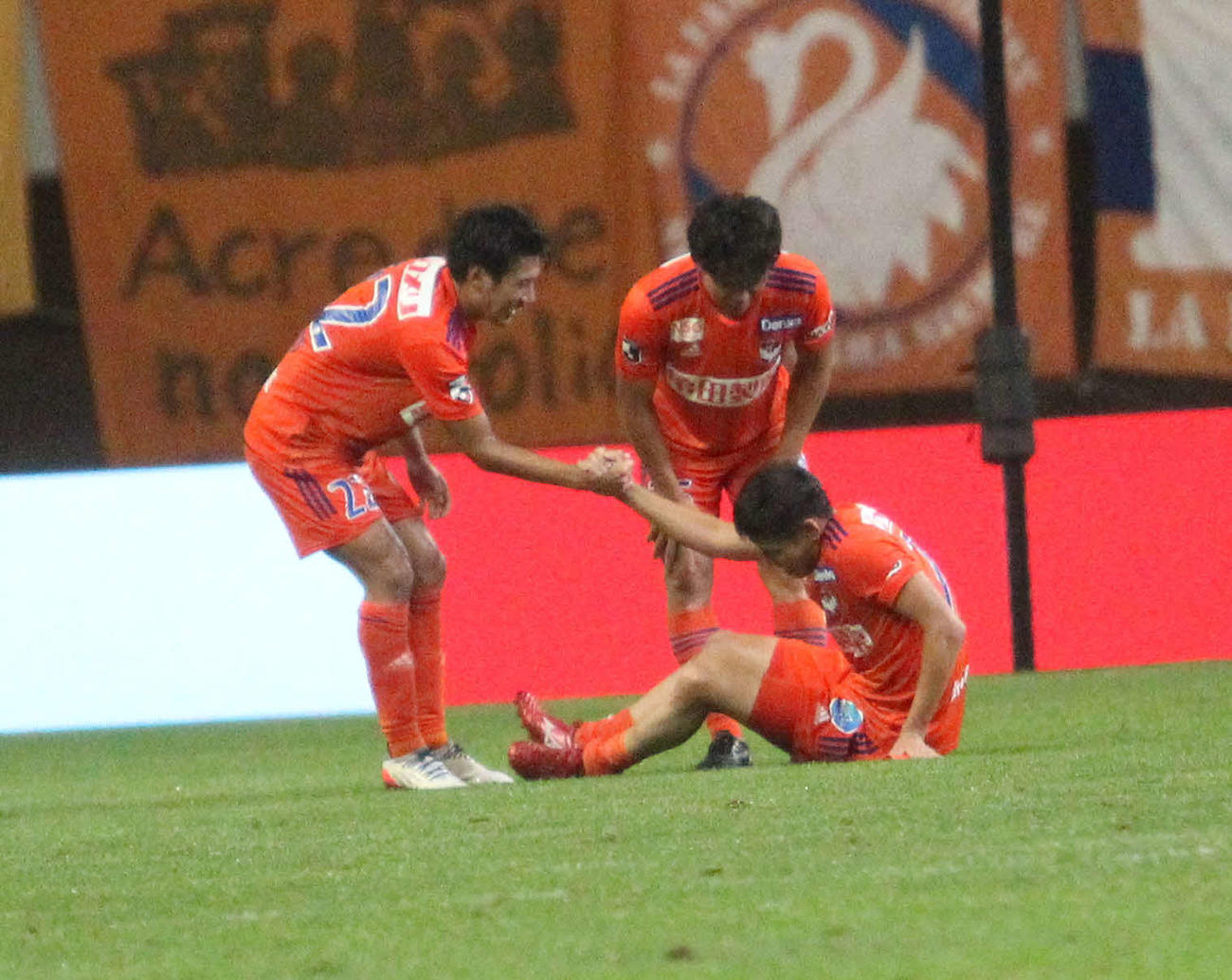 試合終了後、足をつった谷口を笑顔で引っ張りおこす松田