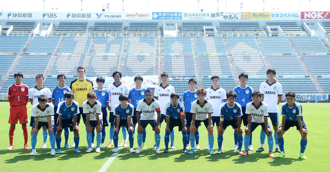試合前に集合写真を撮る両チームの選手たち