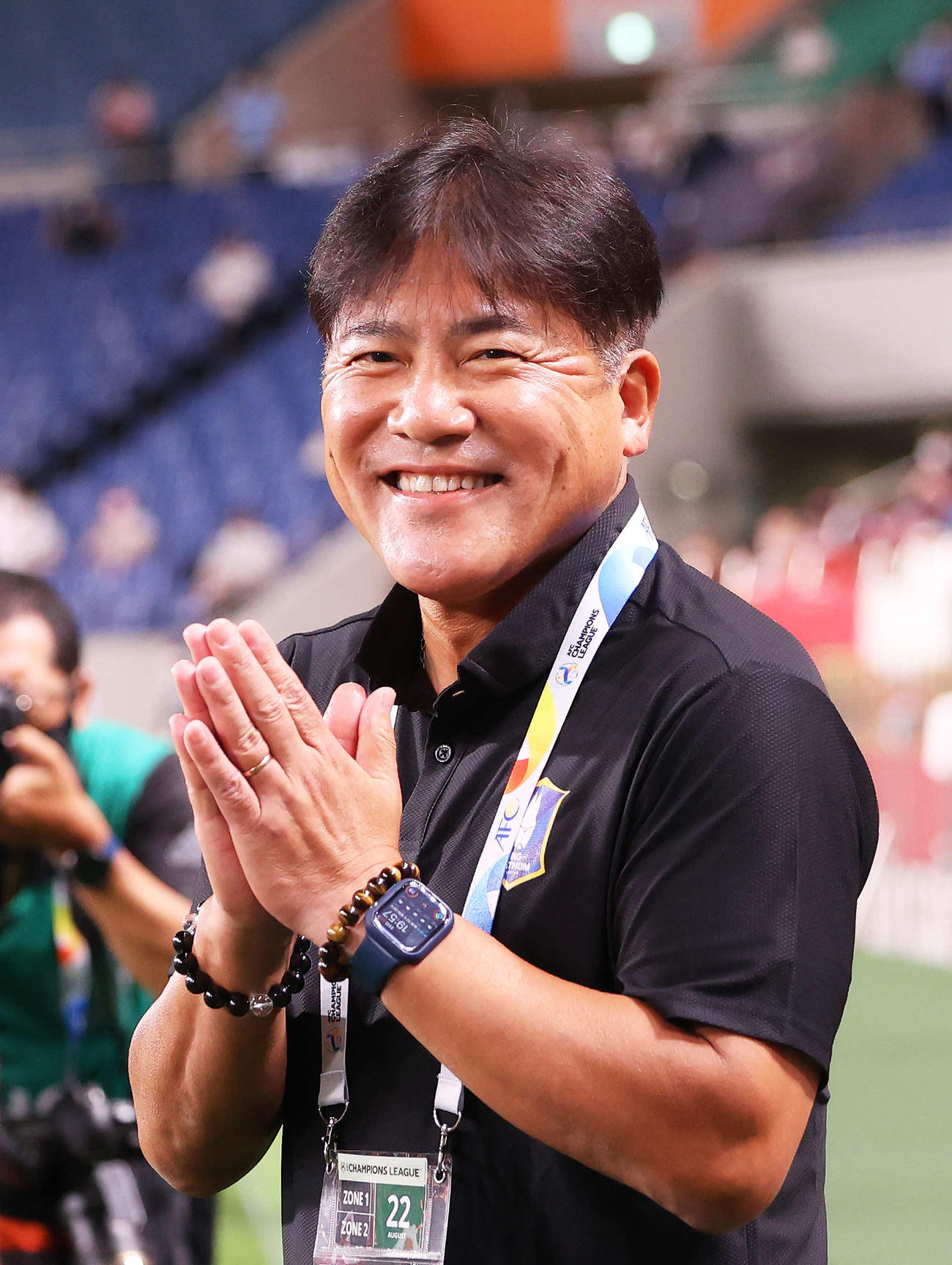 浦和対BGパトゥム　試合開始前、集まる報道陣に手を合わせ笑顔を見せるBGパトゥム手倉森監督（撮影・河田真司）