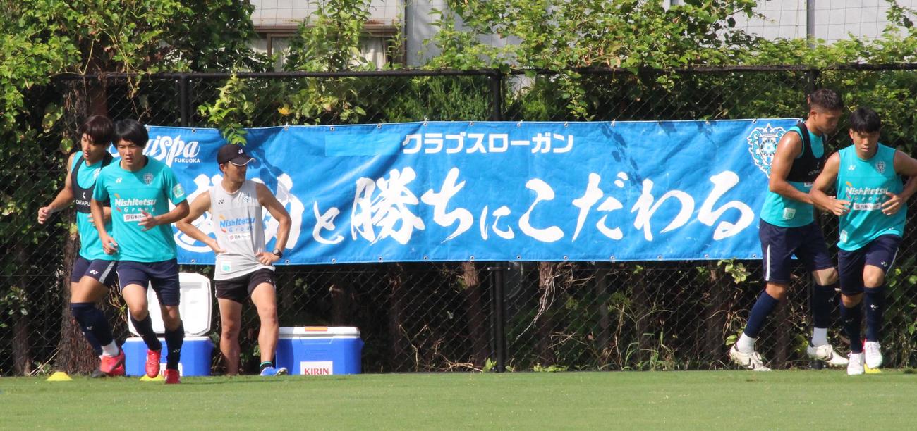 クラブスローガンを前に練習に励むJ1福岡の選手たち（撮影・菊川光一）