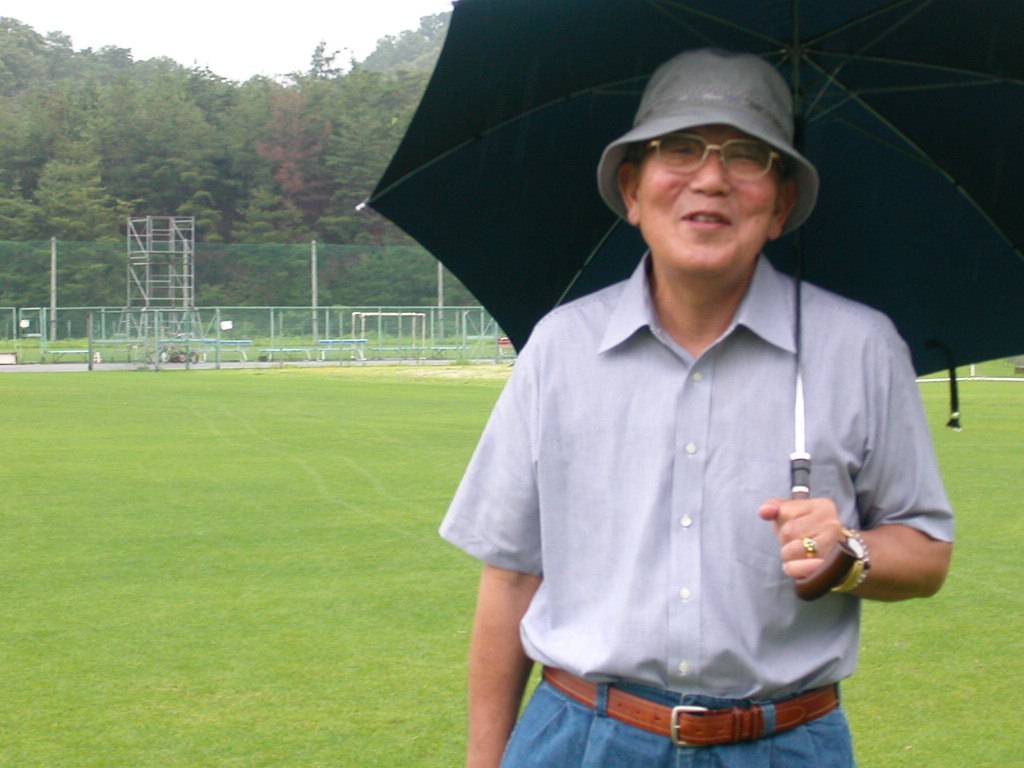 雨の中で練習を視察した稲盛和夫さん（2006年7月18日撮影）