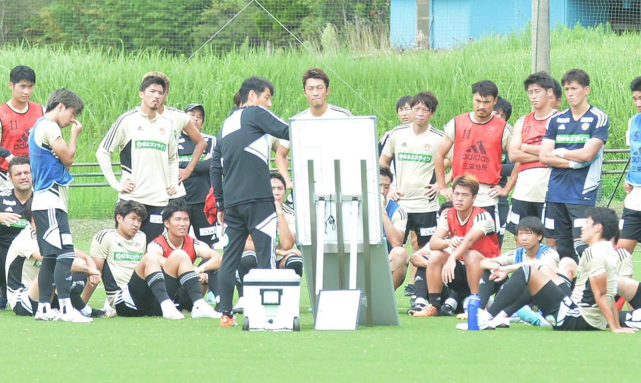 ボードを使って選手に戦術を説明する伊藤新監督（中央）