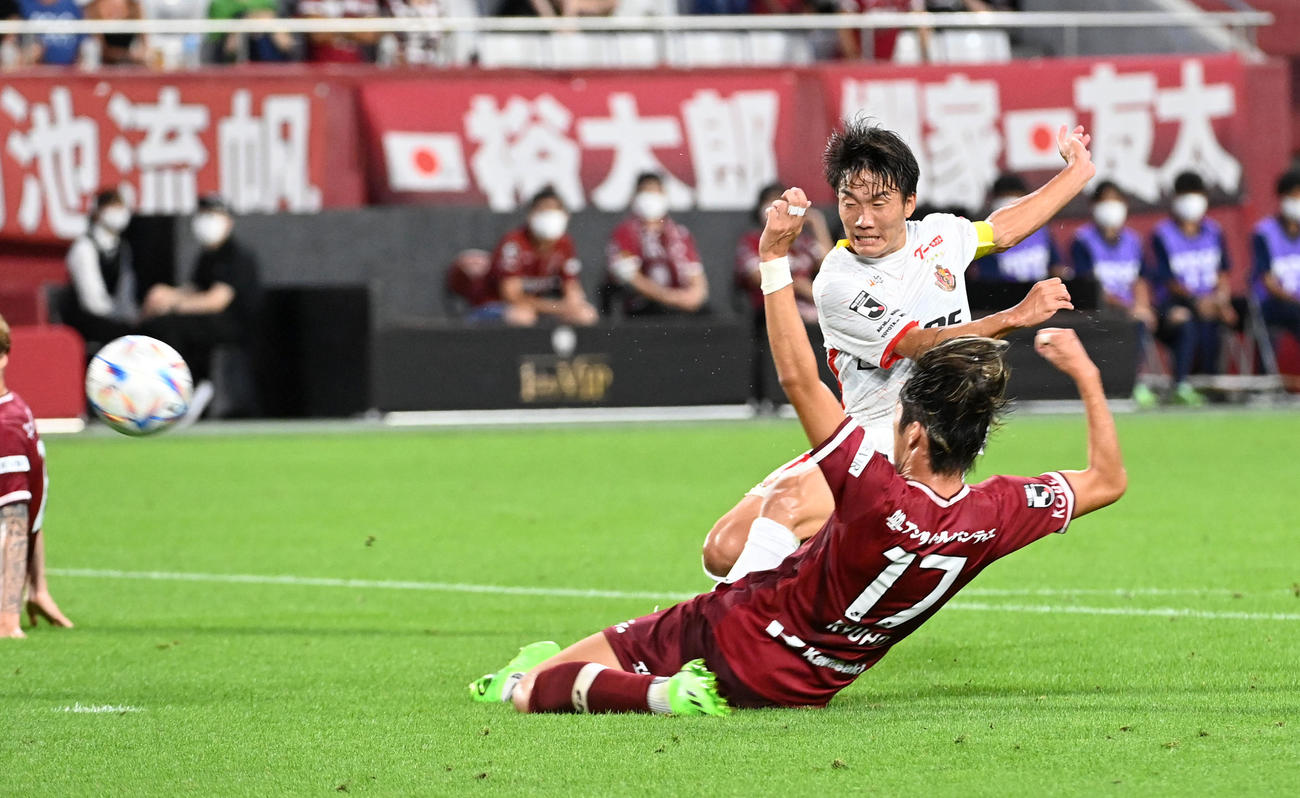神戸対名古屋　前半、シュートを放つ名古屋稲垣（左）と阻止しようとする神戸菊池（撮影・前岡正明）