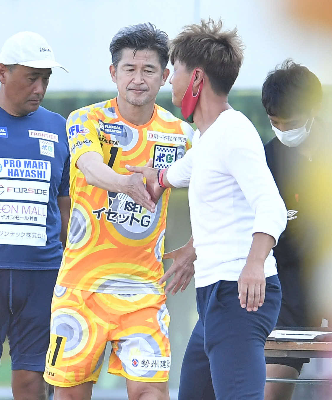 高知対鈴鹿　後半、交代で出場する鈴鹿・三浦知良（左）は、高知・吉本岳史監督と握手を交わす（撮影・岩下翔太）