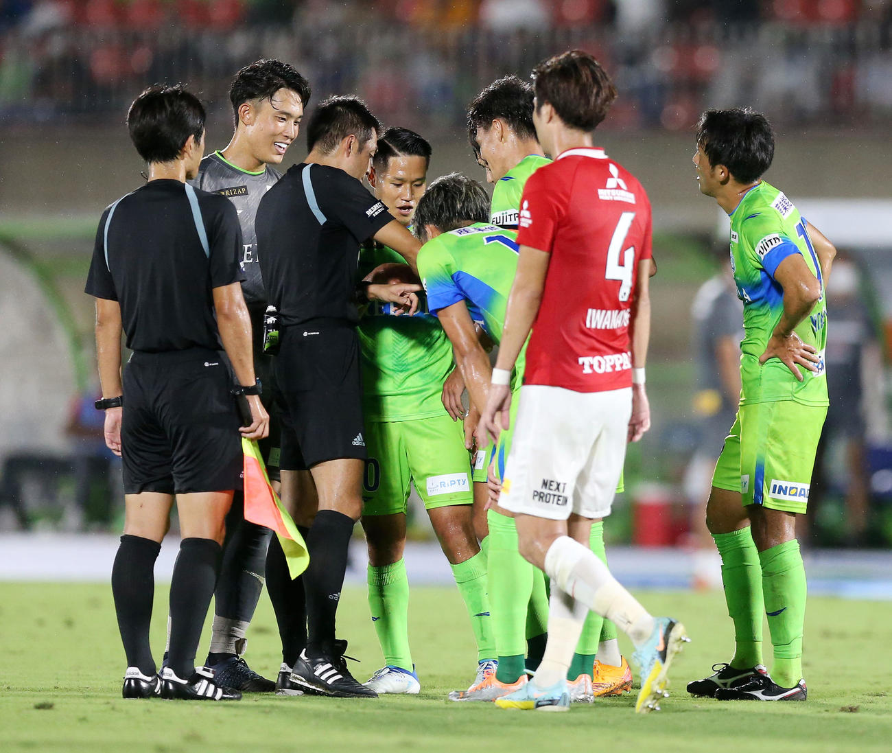 湘南対浦和　後半、CKになるも試合終了の笛を吹き抗議する湘南の選手たちに時計を見せる主審の岡部（左から3人目）（撮影・宮地輝）