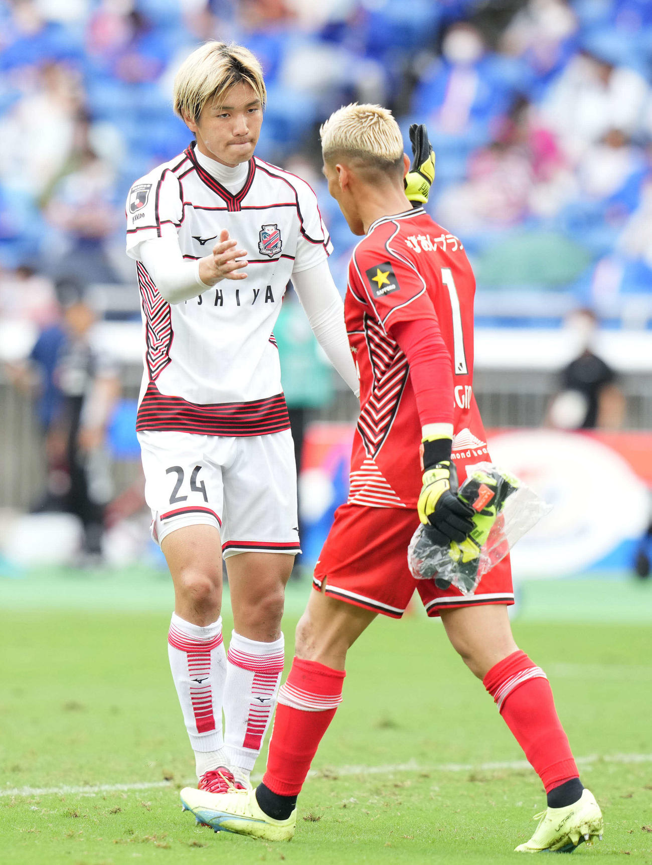 横浜対札幌　スコアレスドローに終わり、中村（左）とタッチを交わす札幌GK菅野（撮影・鈴木みどり）