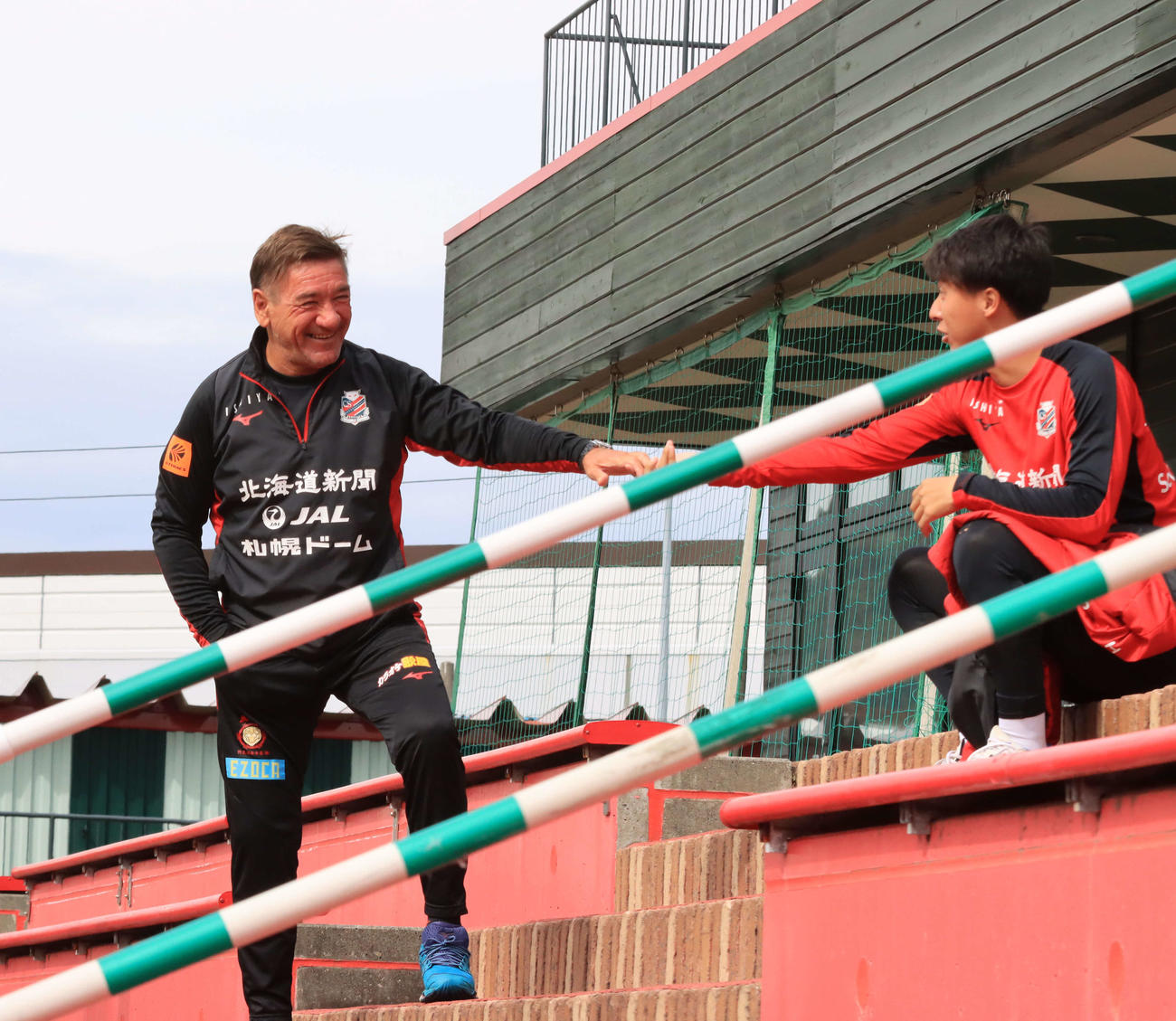 札幌ペトロビッチ監督（左）は荒野と談笑する（撮影・保坂果那）