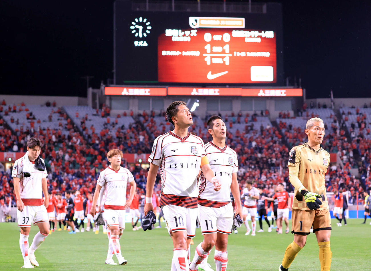 1－1の引き分けとなり、スコアボードを背にサポーターの元にあいさつに向かう宮沢（中央）ら札幌イレブン（撮影・浅見桂子）