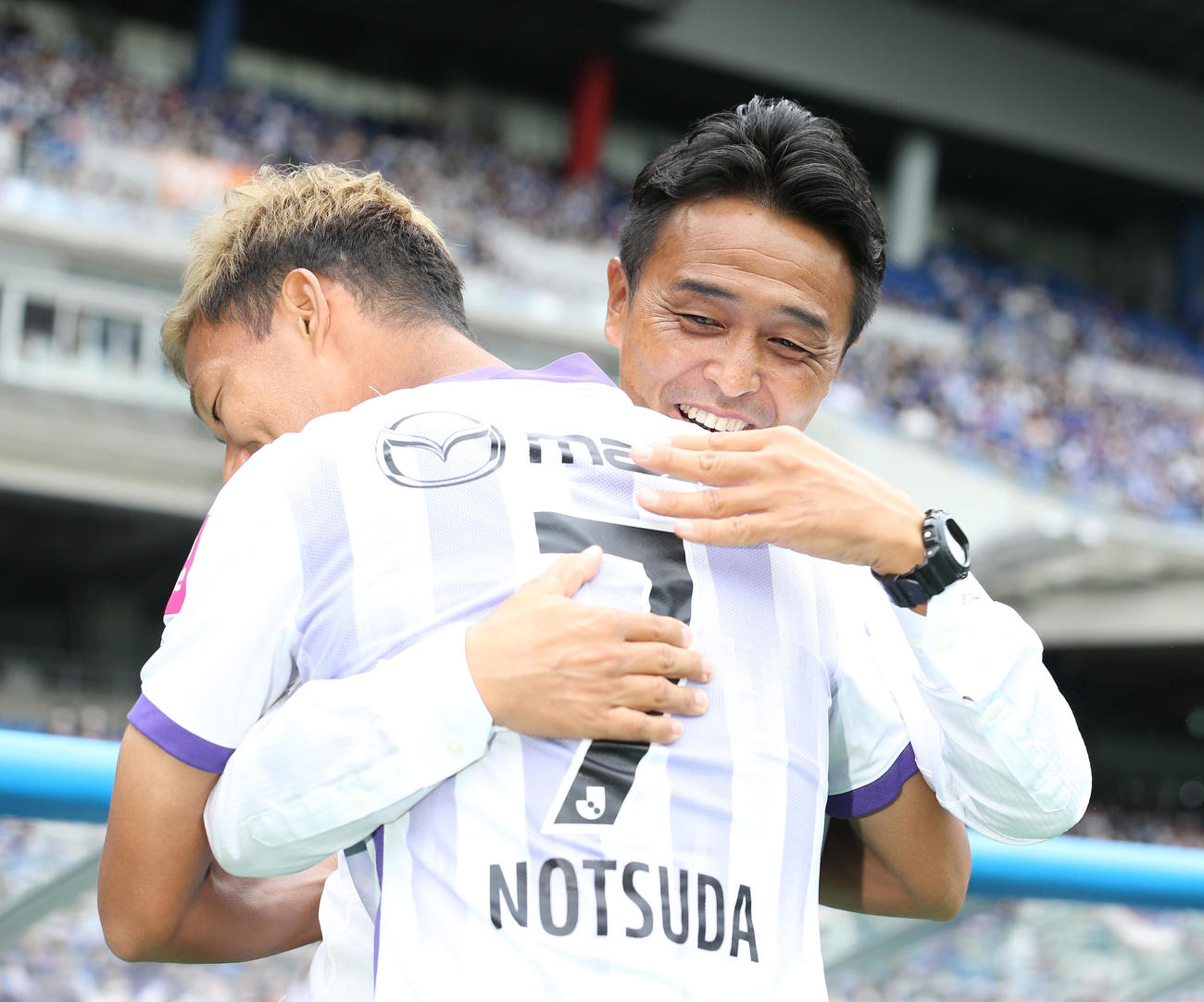甲府対広島　試合前、広島野津田（手前）と笑顔で抱擁を交わす甲府吉田監督（撮影・宮地輝）