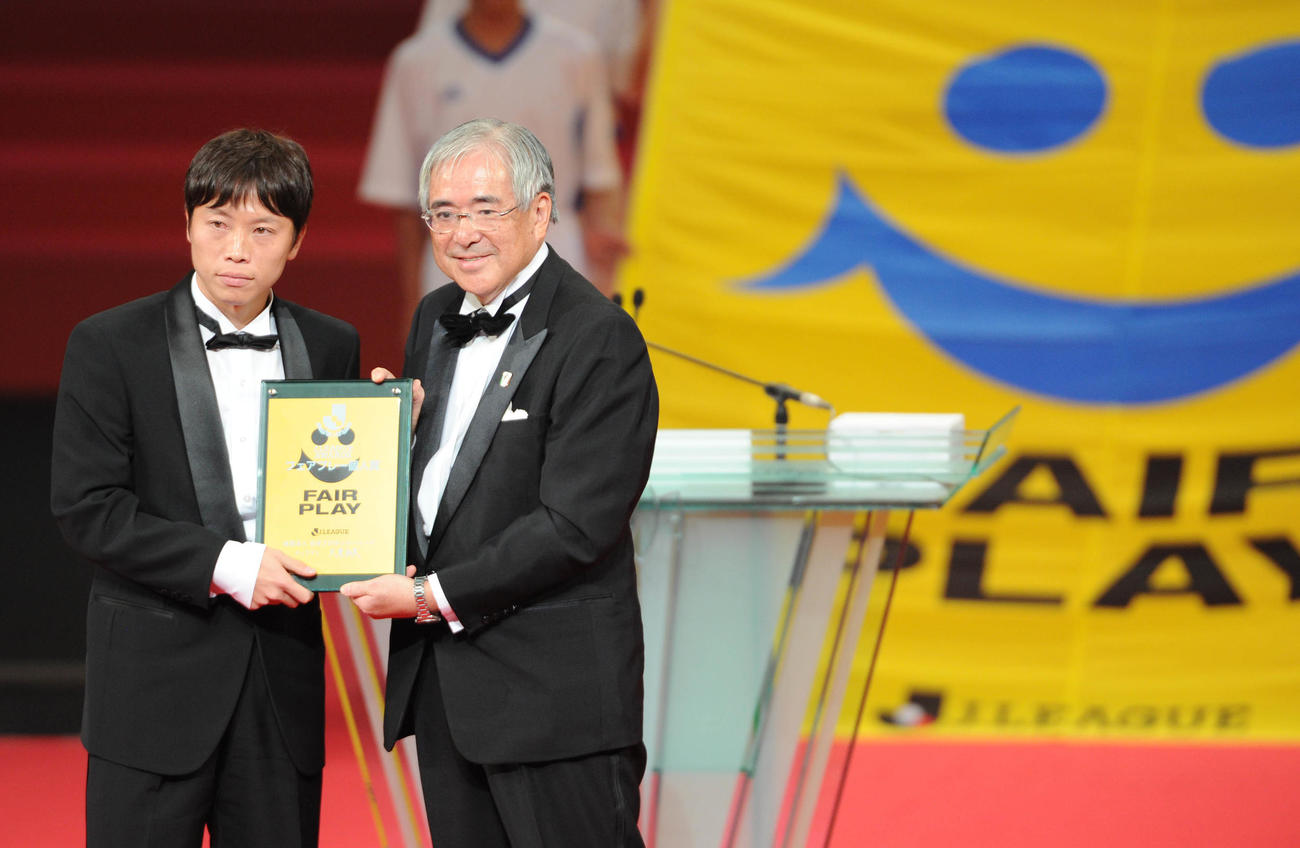 フェアプレー個人賞を受賞し小倉日本サッカー協会会長（右）から記念品を受け取る仙台の梁勇基（2011年12月5日撮影）