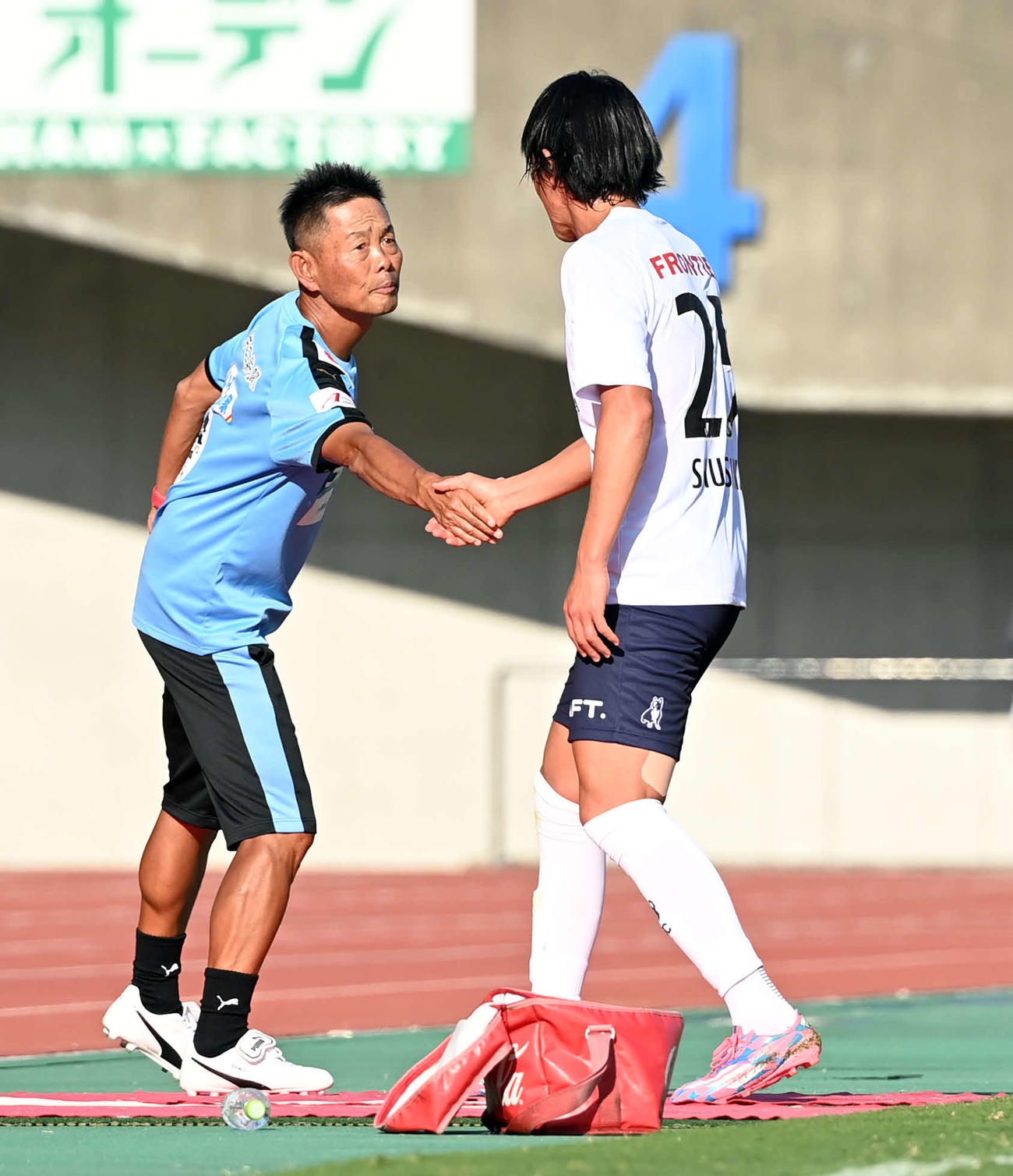 熊本対横浜FC　後半、ベンチに下がる横浜FC中村と握手を交わす熊本の大木監督（撮影・たえ見朱実）