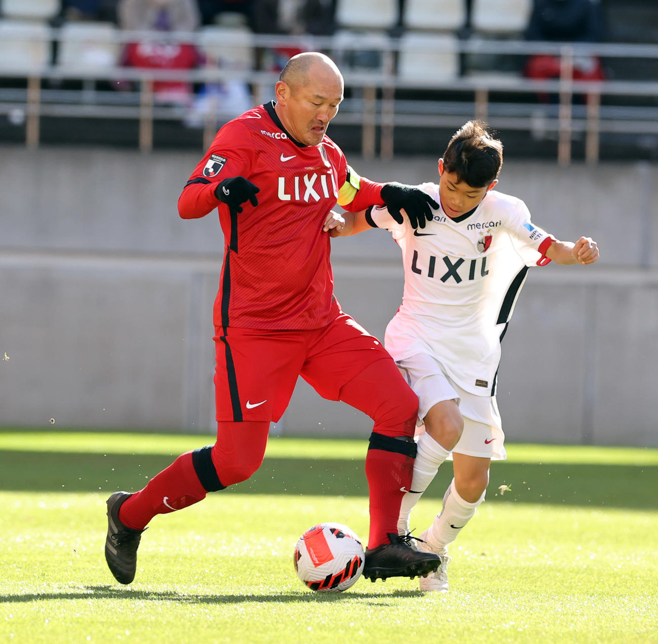 鹿島OB対鹿島アカデミー　30分マッチでアカデミーの選手とボールを競り合う秋田豊氏（2021年12月26日撮影）