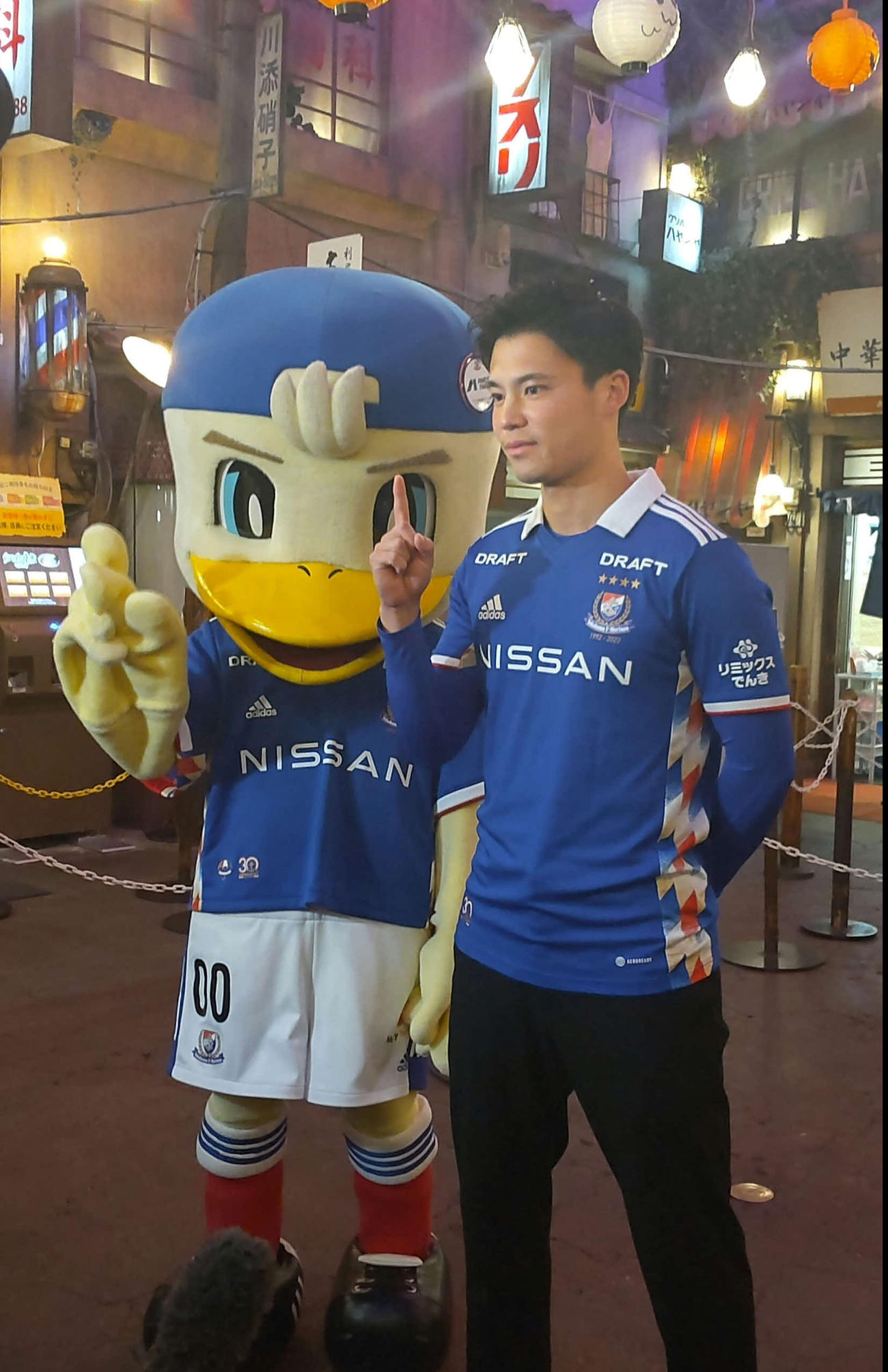 浦和戦のPRに訪れた新横浜ラーメン博物館でマスコットのマリノスケとポーズをとる横浜宮市