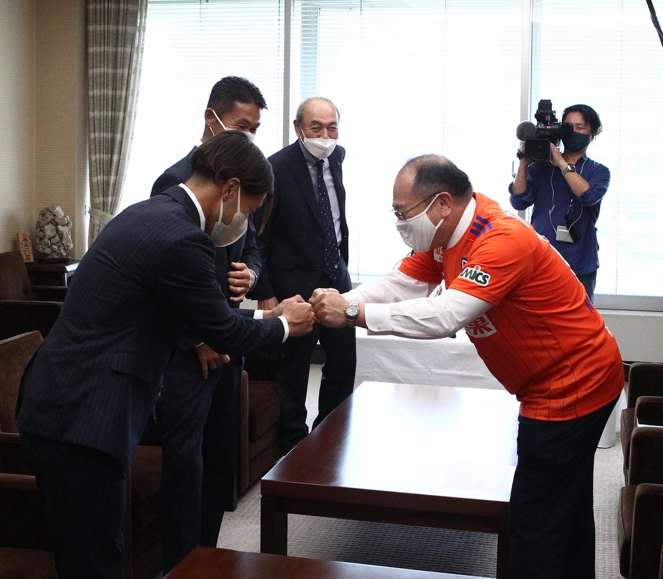 J2優勝とJ1昇格を報告し、橋本副知事（右）とグータッチするJ2新潟の堀米主将