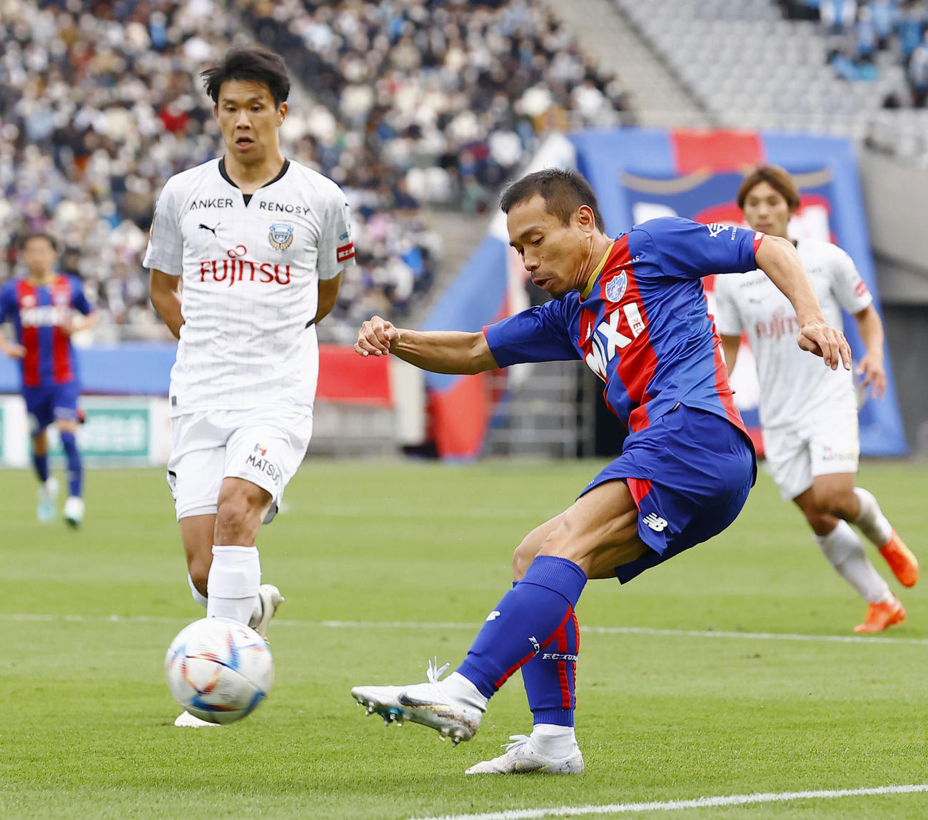 後半、クロスを上げるFC東京長友。左は川崎F山根（共同）