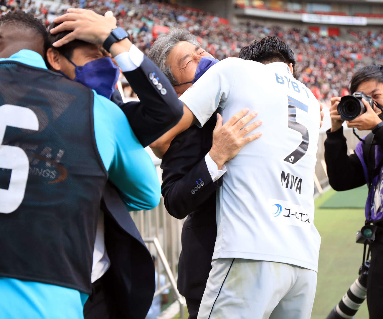 浦和対福岡　J1残留が決まり選手と抱き合う福岡長谷部監督（中央）（撮影・浅見桂子）