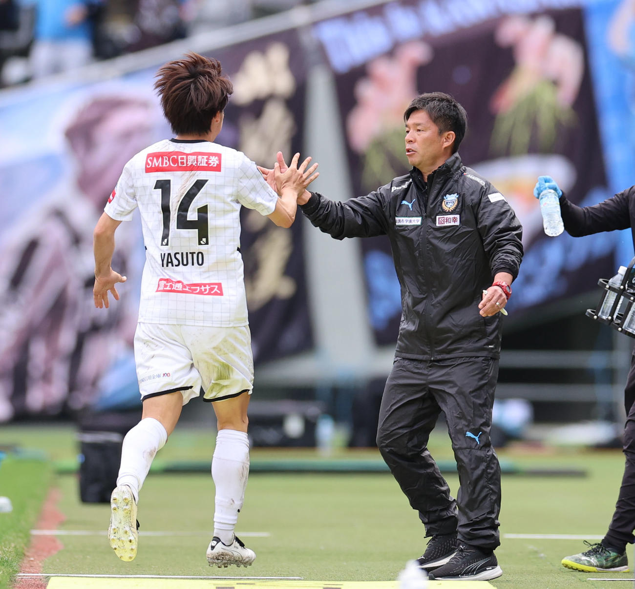 東京対川崎F　前半、先制ゴールを決めた川崎F脇坂（左）とタッチを交わす鬼木監督（撮影・狩俣裕三）