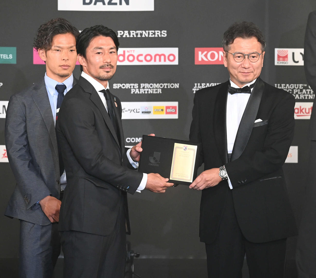 ベストイレブンに選ばれ、代表して盾を受け取る川崎Fの家長。右は野々村チェアマン（撮影・たえ見朱実）