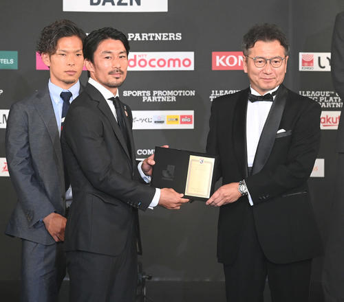 ベストイレブンに選ばれ、代表して盾を受け取る川崎Fの家長。右は野々村チェアマン（撮影・たえ見朱実）