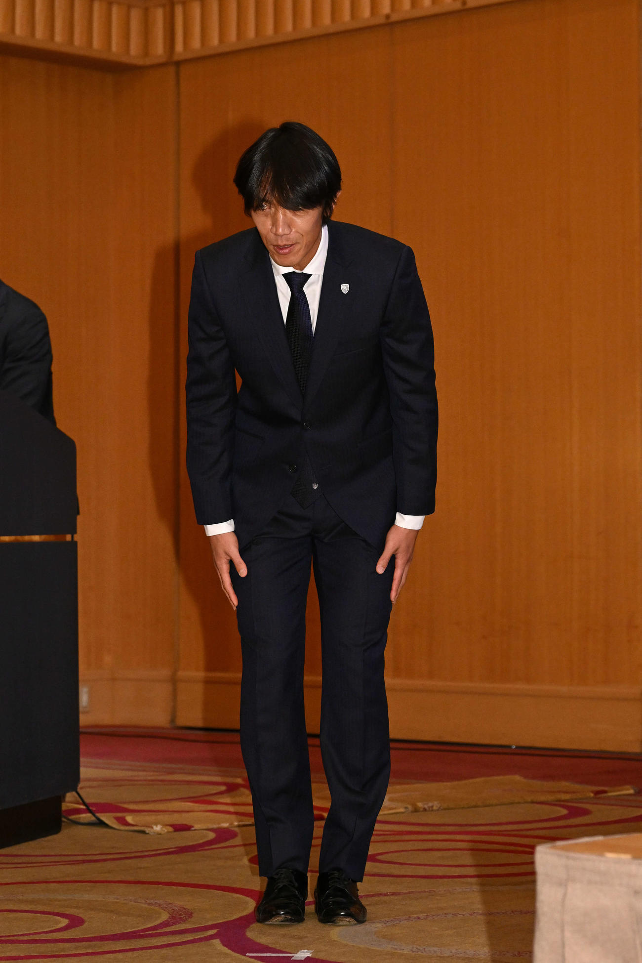 引退記者会見の会場に入り一礼する横浜FC中村（撮影・滝沢徹郎）