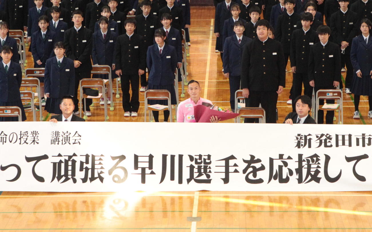 豊浦中学校で講師を務め、記念撮影に収まる早川（中央）