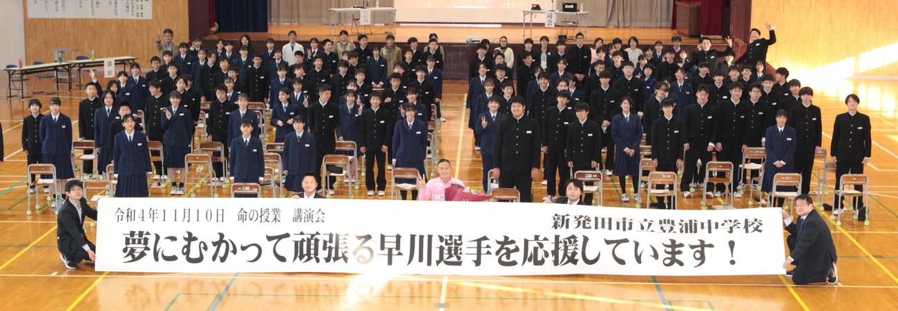 豊浦中学校で講師を務め、記念撮影に収まる早川（中央）