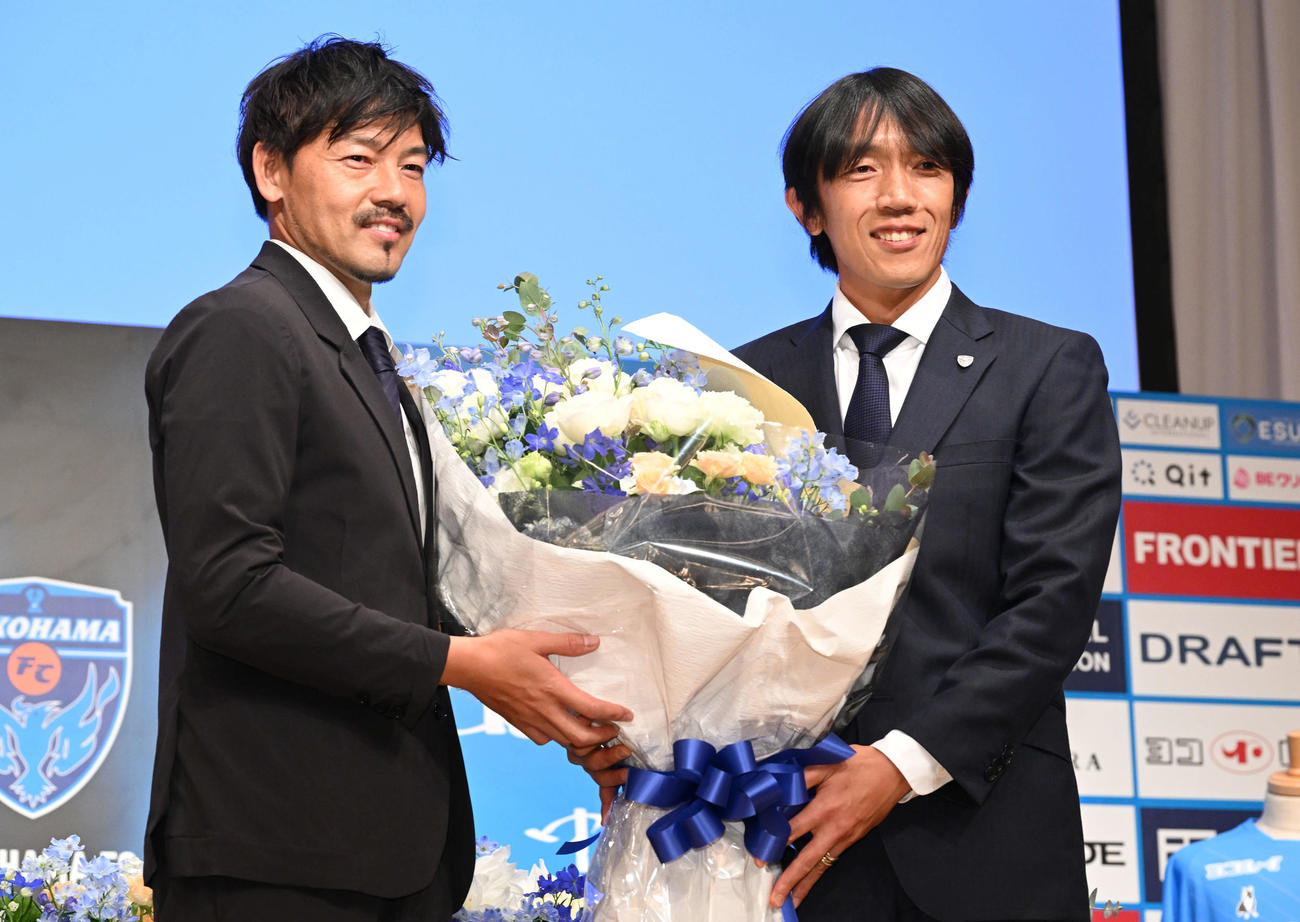 引退記者会見でサプライズゲストのYS横浜松井（左）から花束を受け取る横浜FC中村（撮影・滝沢徹郎）