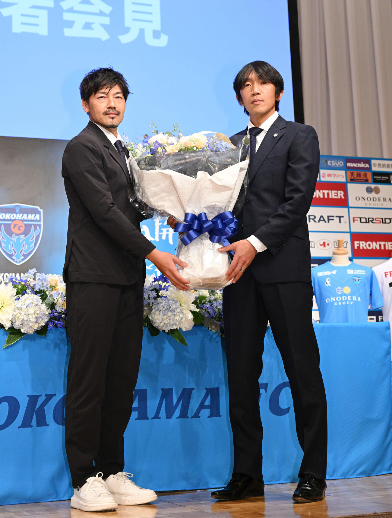 引退記者会見でサプライズゲストのYS横浜松井（左）から花束を受け取る横浜FC中村（撮影・滝沢徹郎）