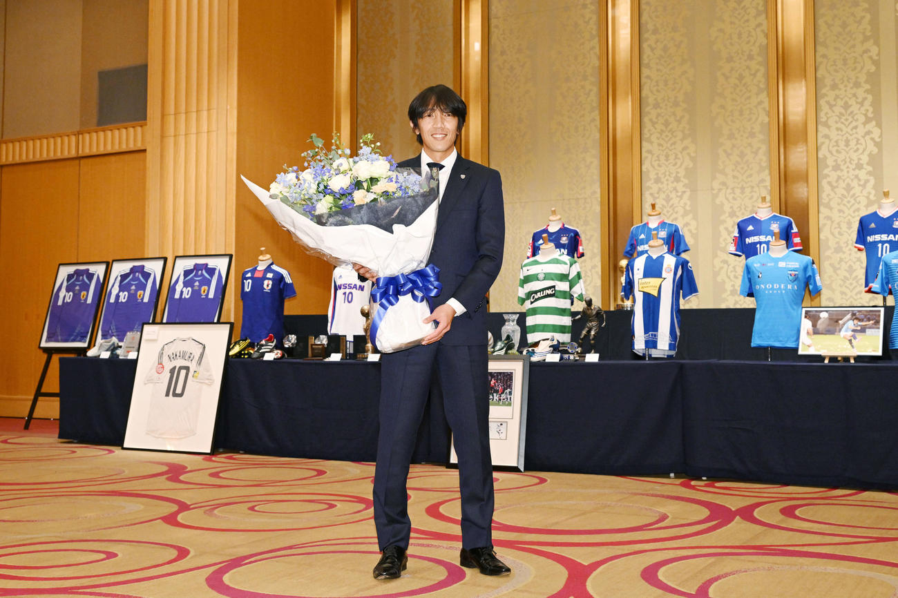 引退記者会見を終え思い出の品々を背に記念撮影する横浜FC中村（撮影・滝沢徹郎）