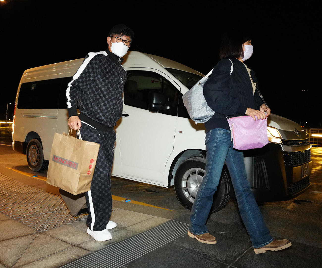 日本帰国のため、空港に到着し、チェックインカウンターへ向かうカズ。右は、りさ子夫人（撮影・江口和貴）