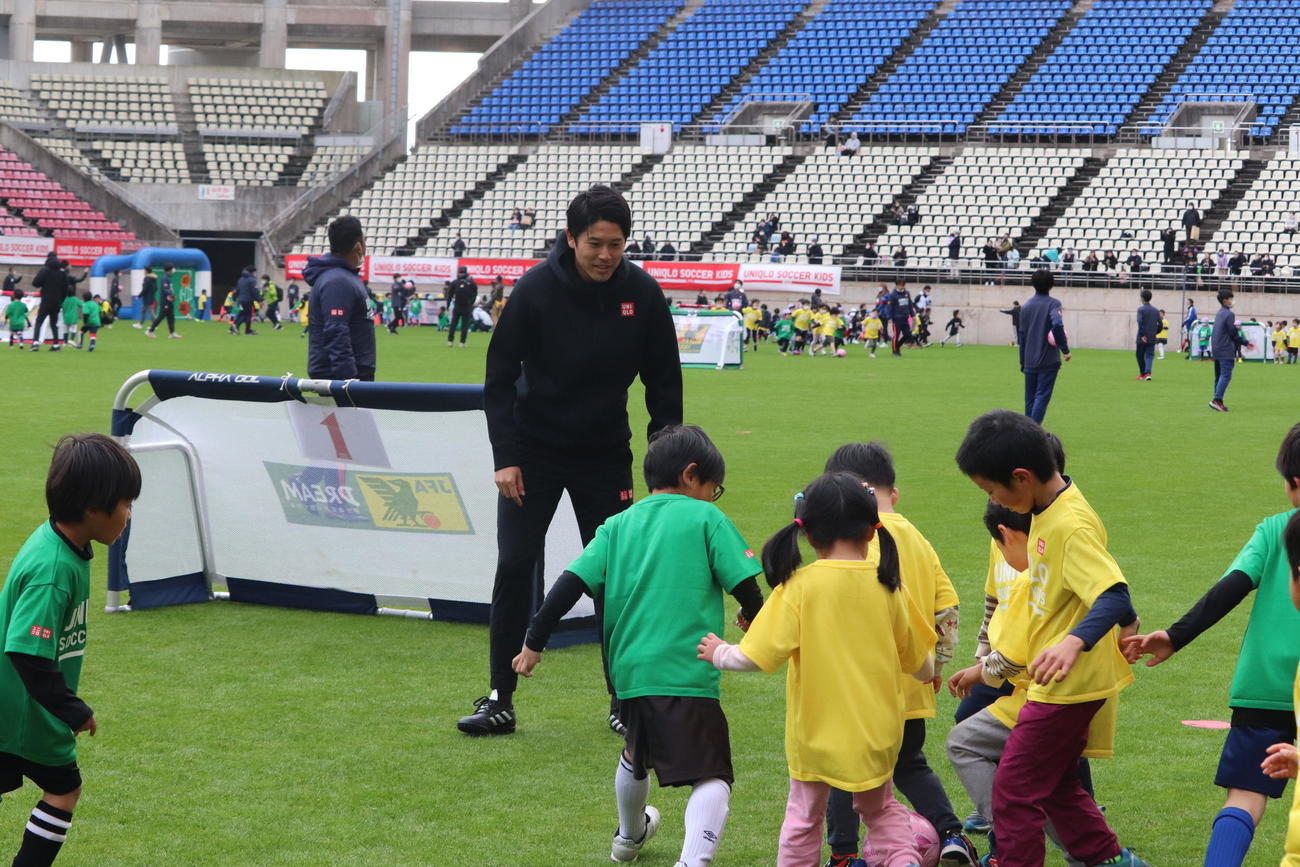 JFAユニクロサッカーキッズのイベントで子供たちとサッカーを楽しむ内田篤人氏（中央）