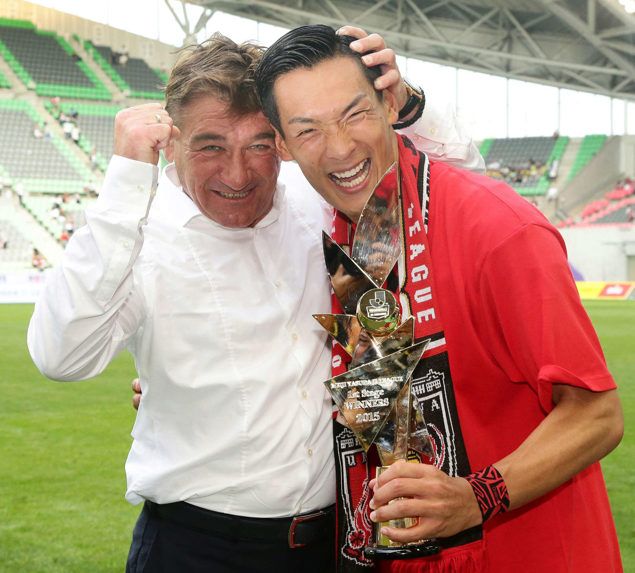 15年6月20日、第1ステージ優勝トロフィーを手にする浦和DF槙野智章（右）とねぎらうミハイロ・ペトロビッチ監督