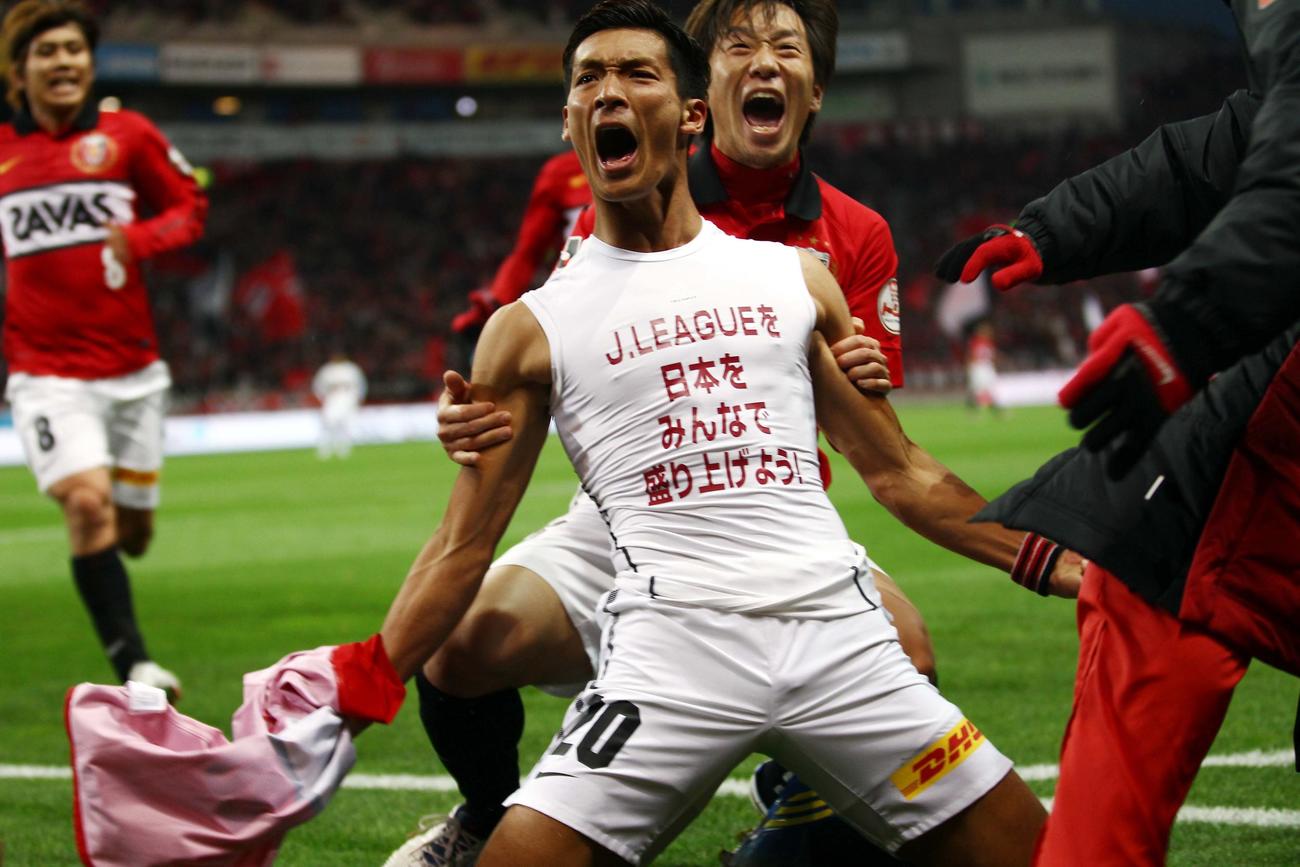 12年12月1日、浦和対名古屋　後半、ゴールを決め、「J.LEAGUEを　日本を　みんなで　盛り上げよう！」と記されたアンダーウエアを披露する浦和DF槙野智章（手前）。後方はMF宇賀神
