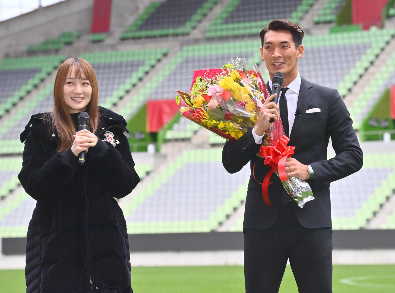 引退会見後、女優で妻の高梨臨から花束を贈られる神戸槙野（撮影・和賀正仁）