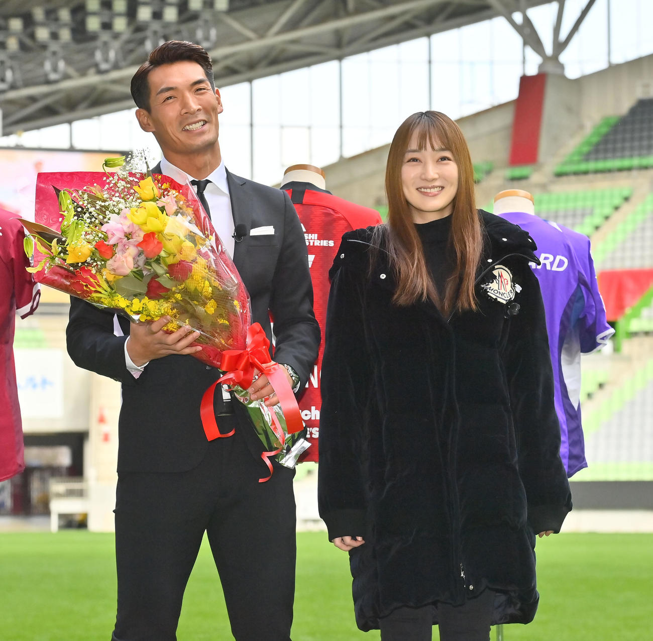 引退会見後、女優で妻の高梨臨から花束を贈られる神戸槙野（撮影・和賀正仁）