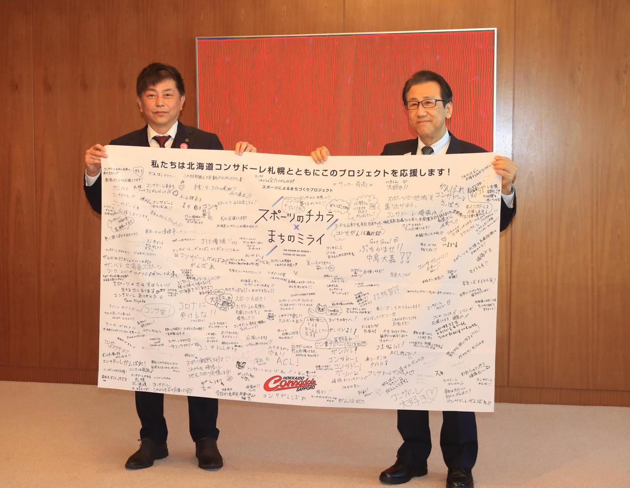 秋元札幌市長（右）に今季の報告をし、寄せ書きを贈呈した札幌三上代表取締役GM（撮影・保坂果那）