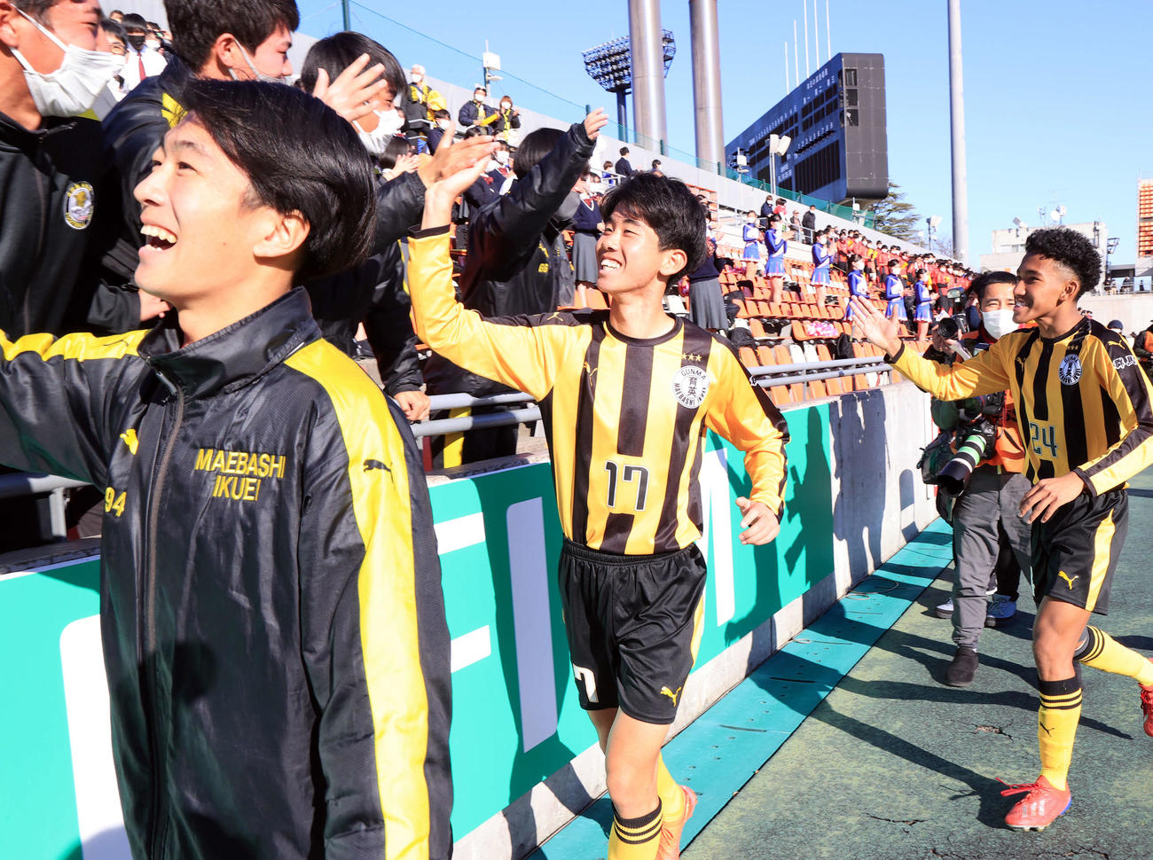 前橋育英対日章学園　初戦突破し、勝ち越しゴールを決めた前橋育英MF山田（中央）は笑顔でスタンドの選手たちとハイタッチ（撮影・浅見桂子）