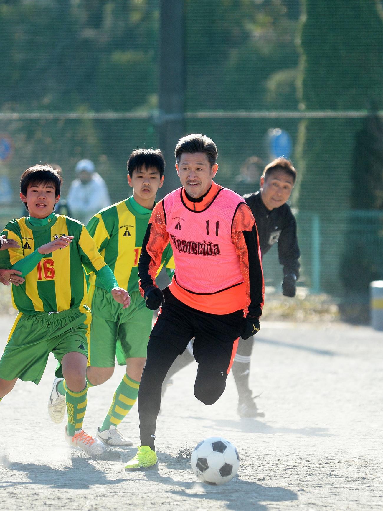 中学生との試合で突破を図るFWカズ