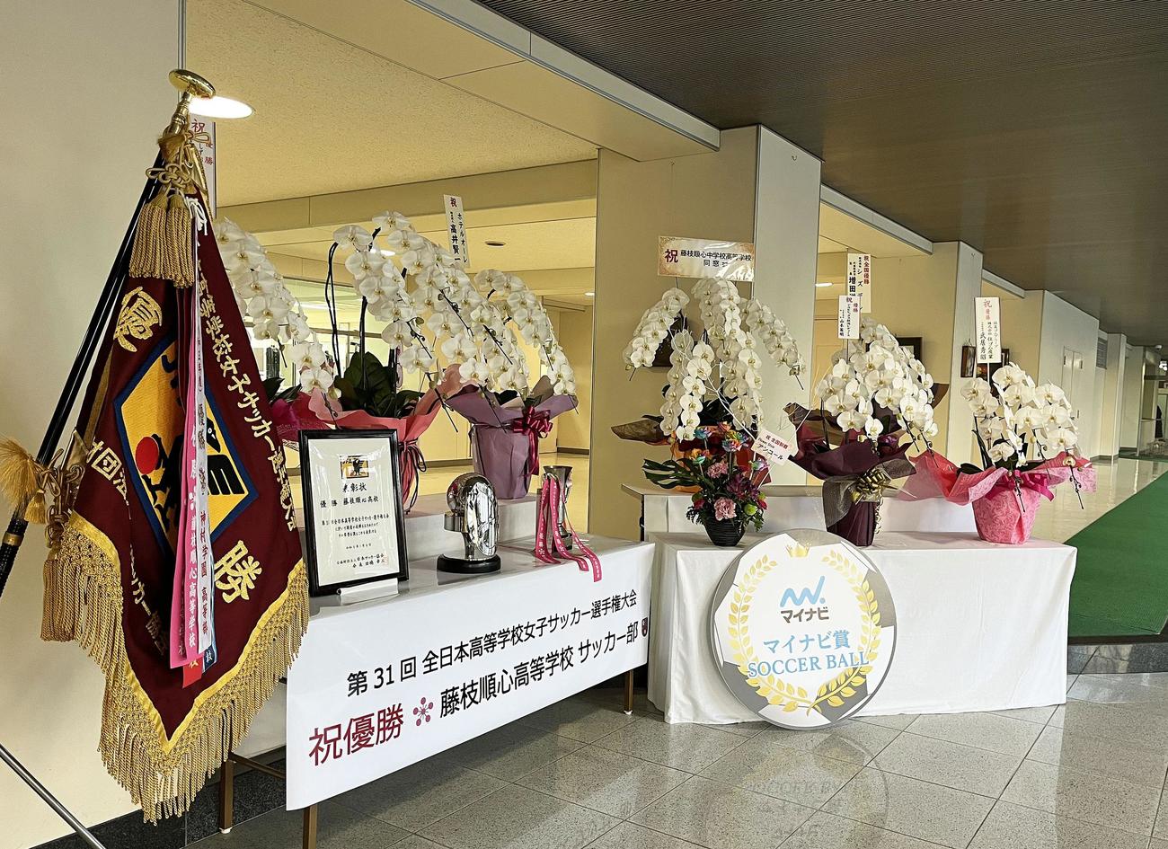 同校の事務室前には大会優勝を祝う花束などが飾られている