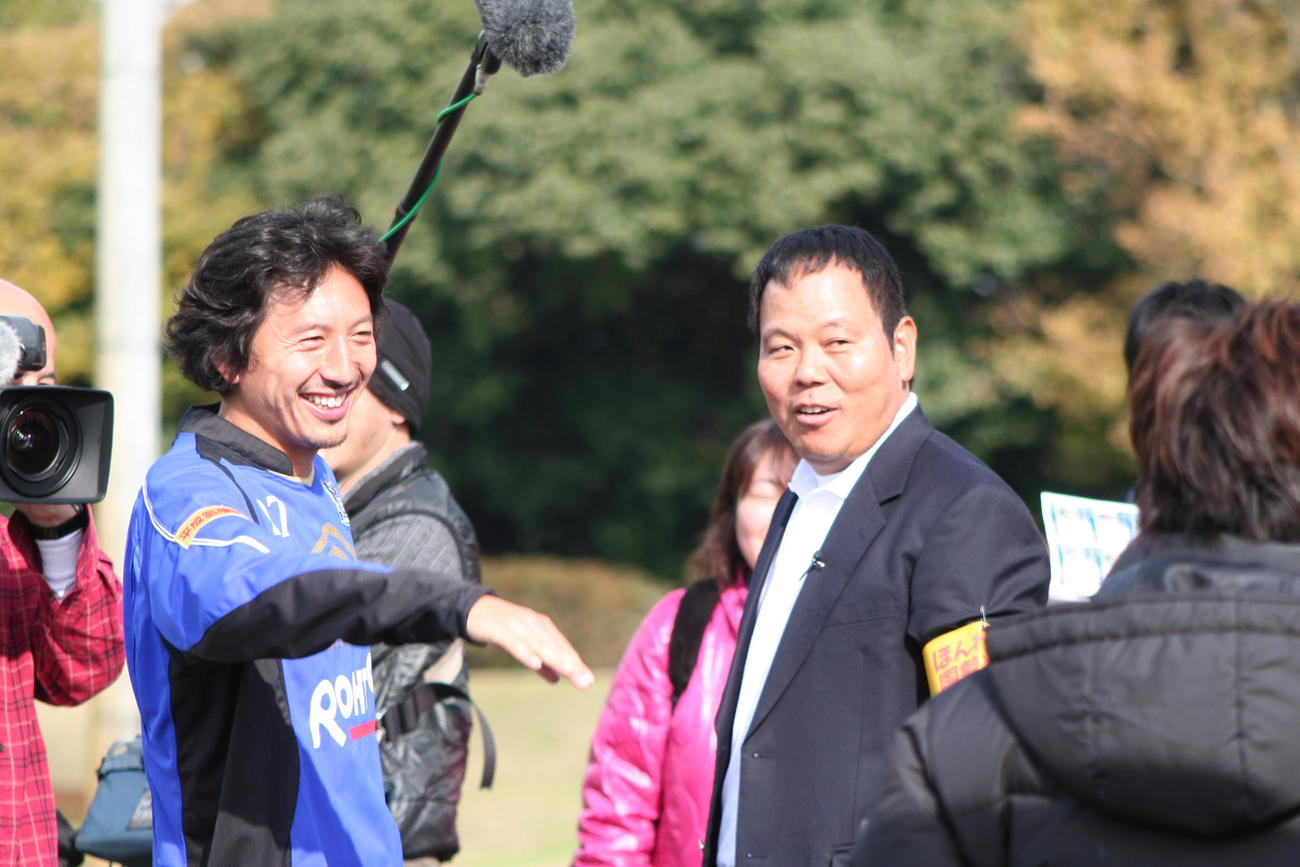 テレビ撮影のため練習場に訪れたお笑い芸人ほんこんと談笑するG大阪のMF橋本（左）（2010年11月30日撮影）