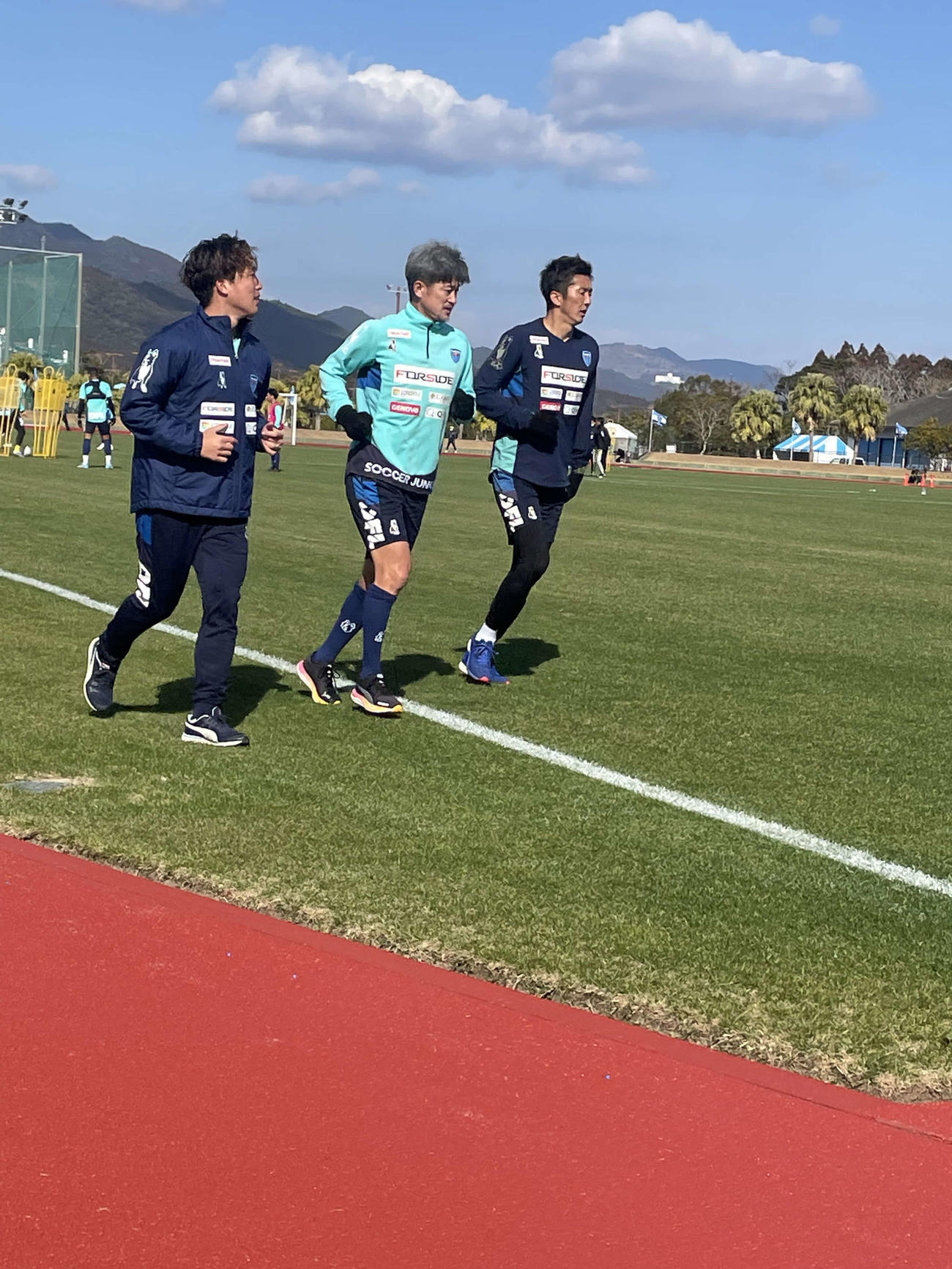 宮崎キャンプ中のJ1横浜FCのトレーニング後、GK六反（右）、DF岩武（左）とジョギングするポルトガル2部オリベイレンセへの期限付き移籍が基本合意に達している元日本代表FWカズ（三浦知良）