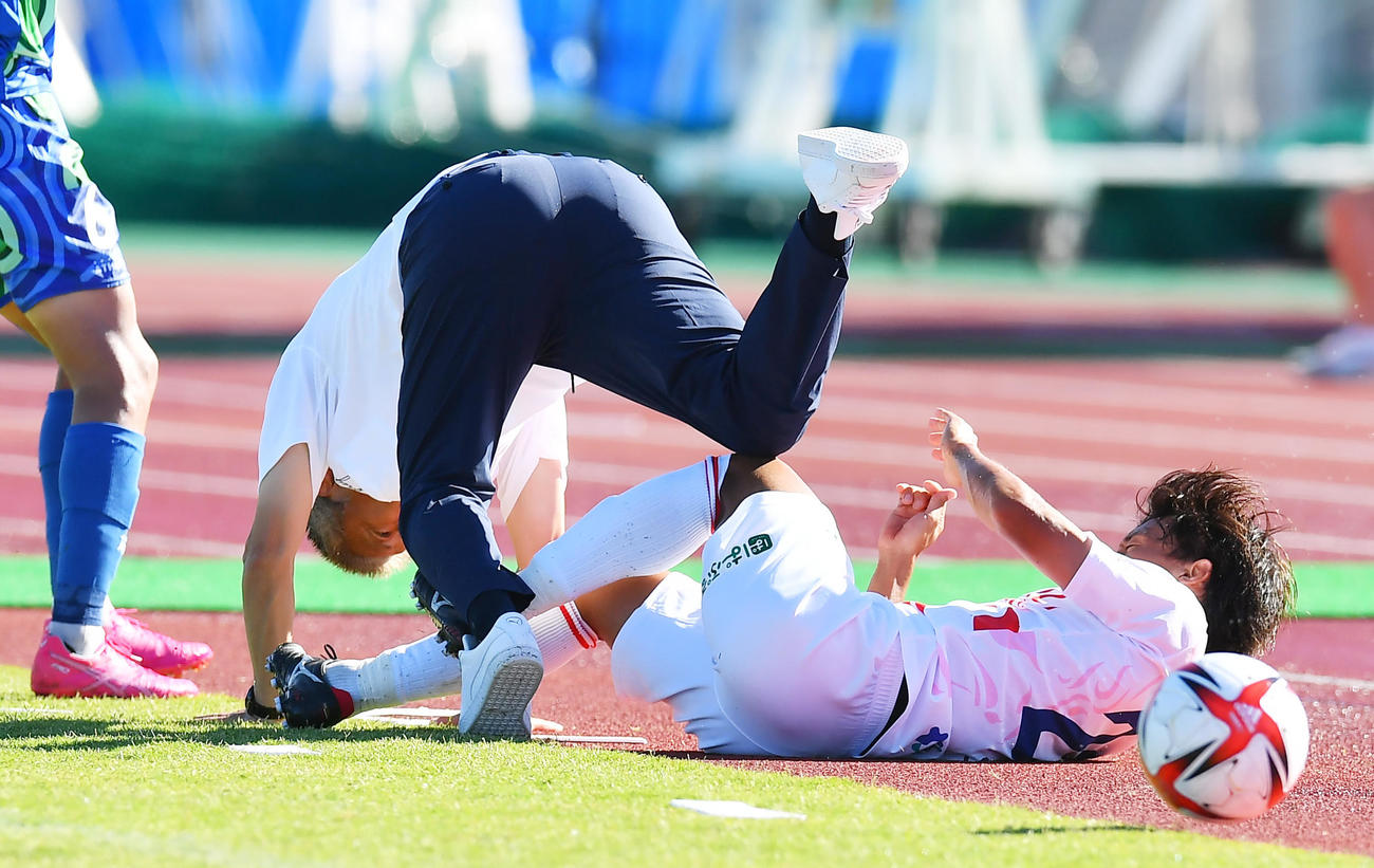 相手選手のタックルに巻き込まれ転倒する鈴鹿三浦監督（中央）（22年7月2日撮影）