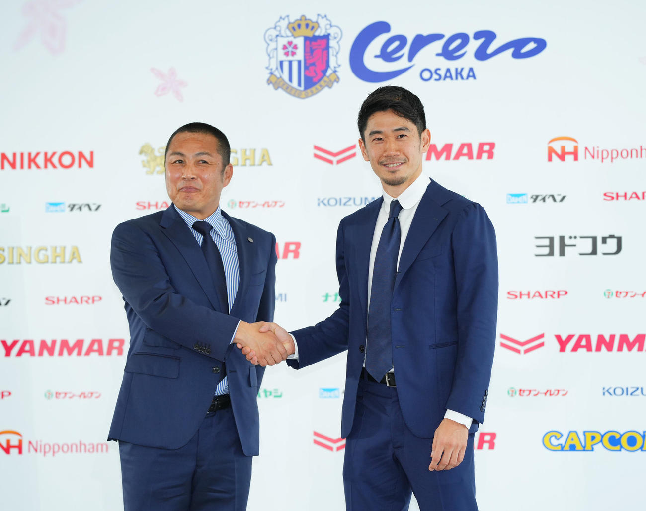 J1C大阪入団会見で森島代表取締役社長（左）と笑顔で握手を交わす香川（撮影・垰建太）