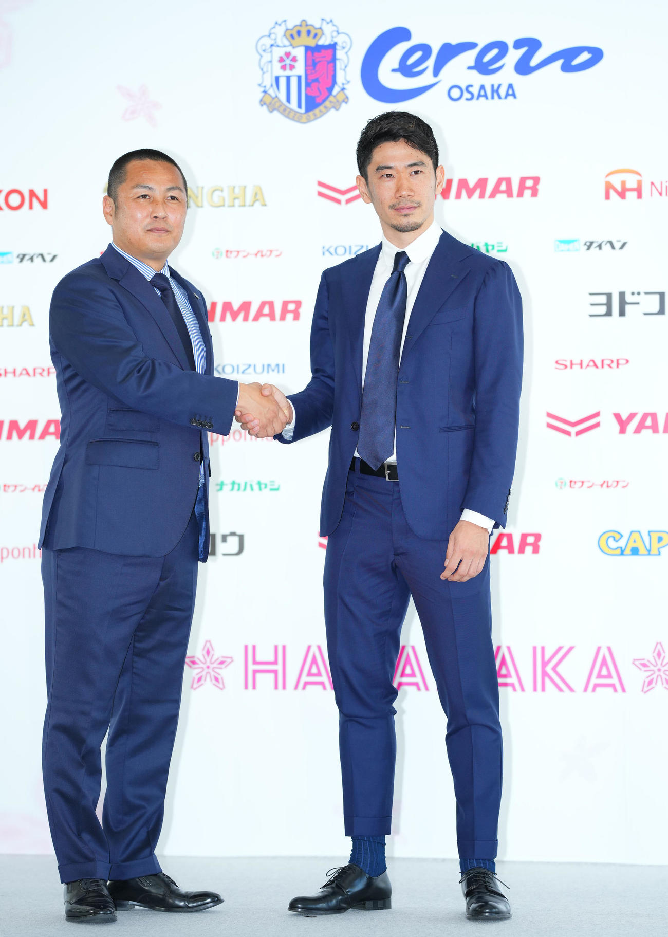 J1C大阪入団会見で森島代表取締役社長（左）と笑顔で握手を交わす香川（撮影・垰建太）