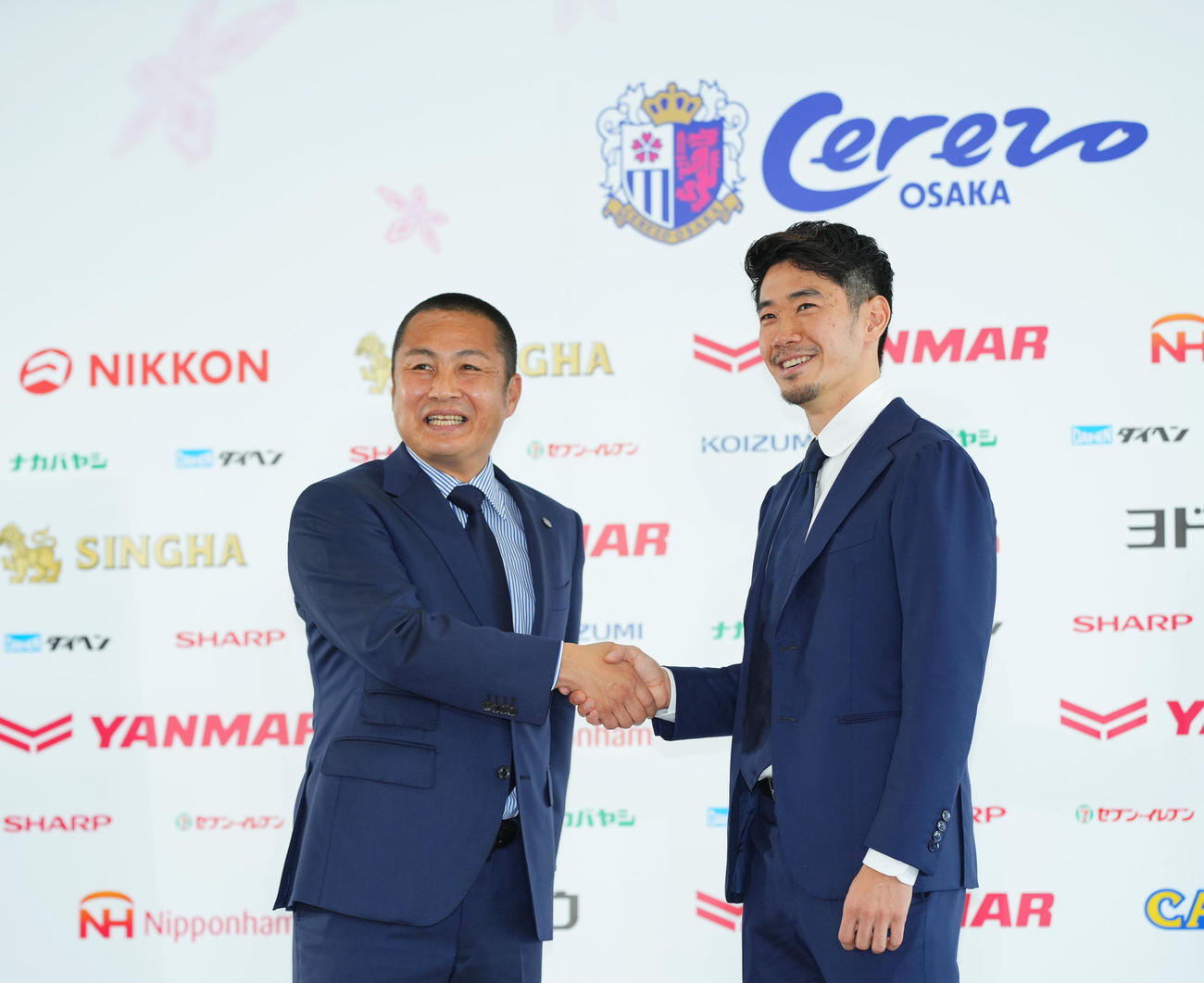 J1C大阪入団会見で森島代表取締役社長（左）と笑顔で握手を交わす香川（撮影・垰建太）
