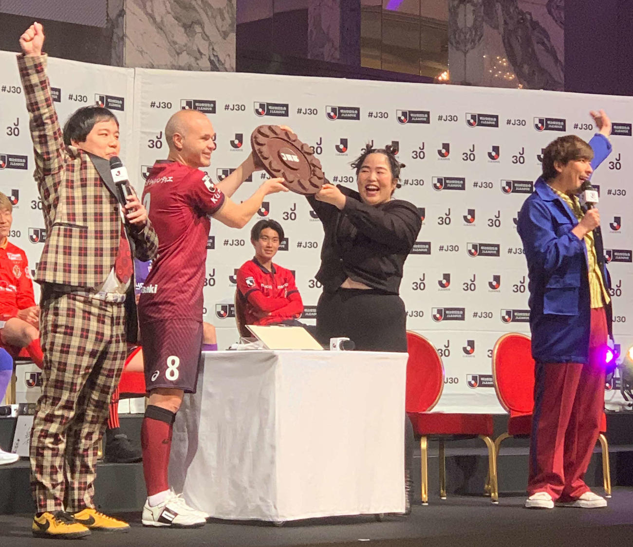「2023Jリーグキックオフカンファレンス」でヴィッセル神戸MFイニエスタ（左から2人目）にチョコレートのシャーレを渡すゆりやんレトリイバァ（同3人目）。左端は霜降り明星のせいや、右端はEXITのりんたろー。（撮影・松尾幸之介）