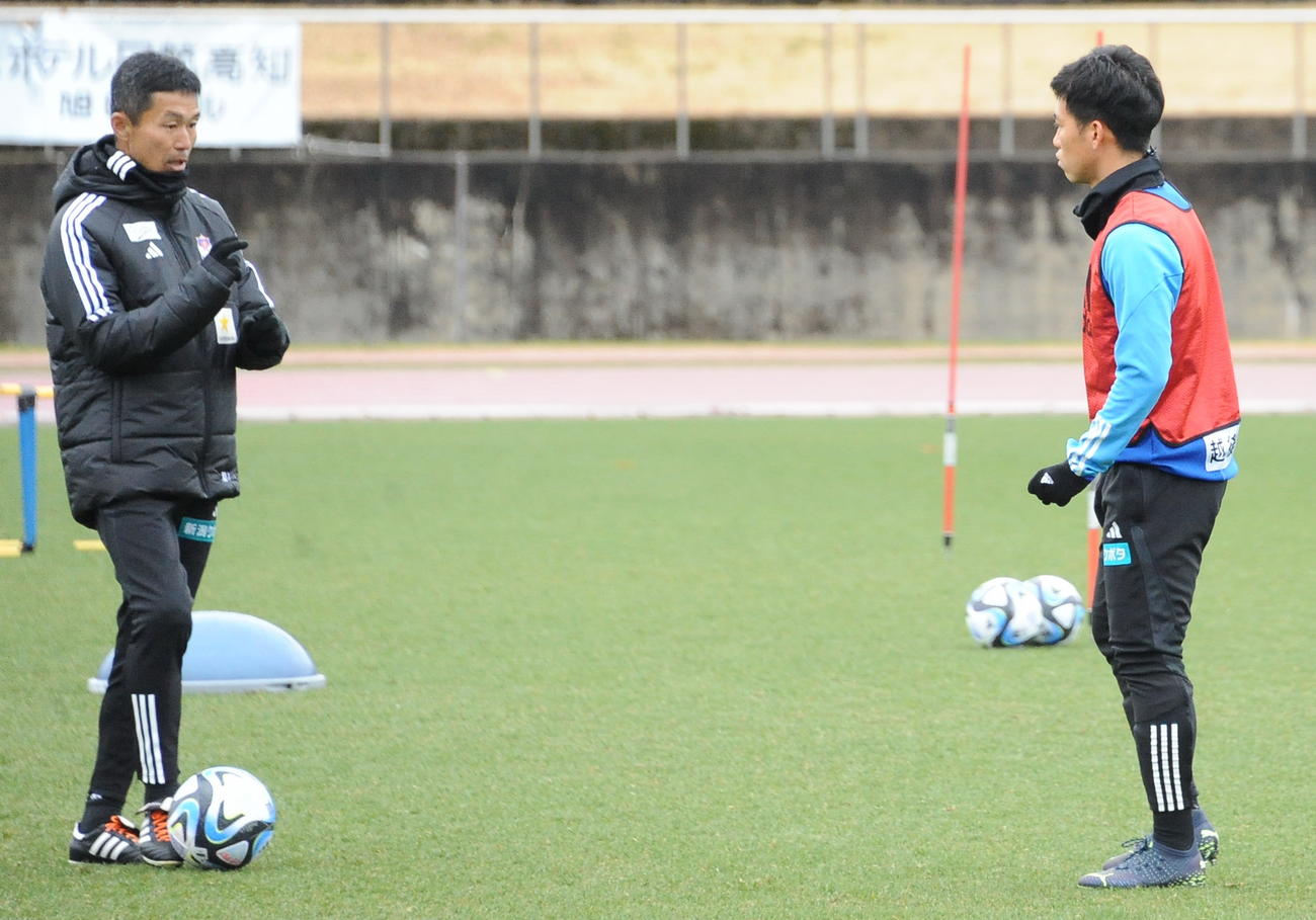 高知での1次キャンプ、練習前に松橋監督（左）から助言を受ける高（2月7日撮影）