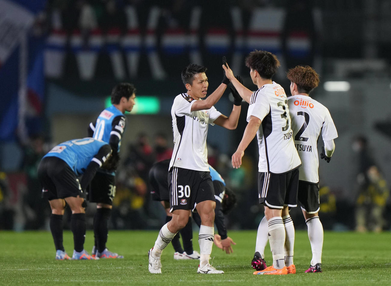 川崎F対横浜　チームメートと開幕戦勝利を喜ぶ横浜西村（中央）（撮影・狩俣裕三）