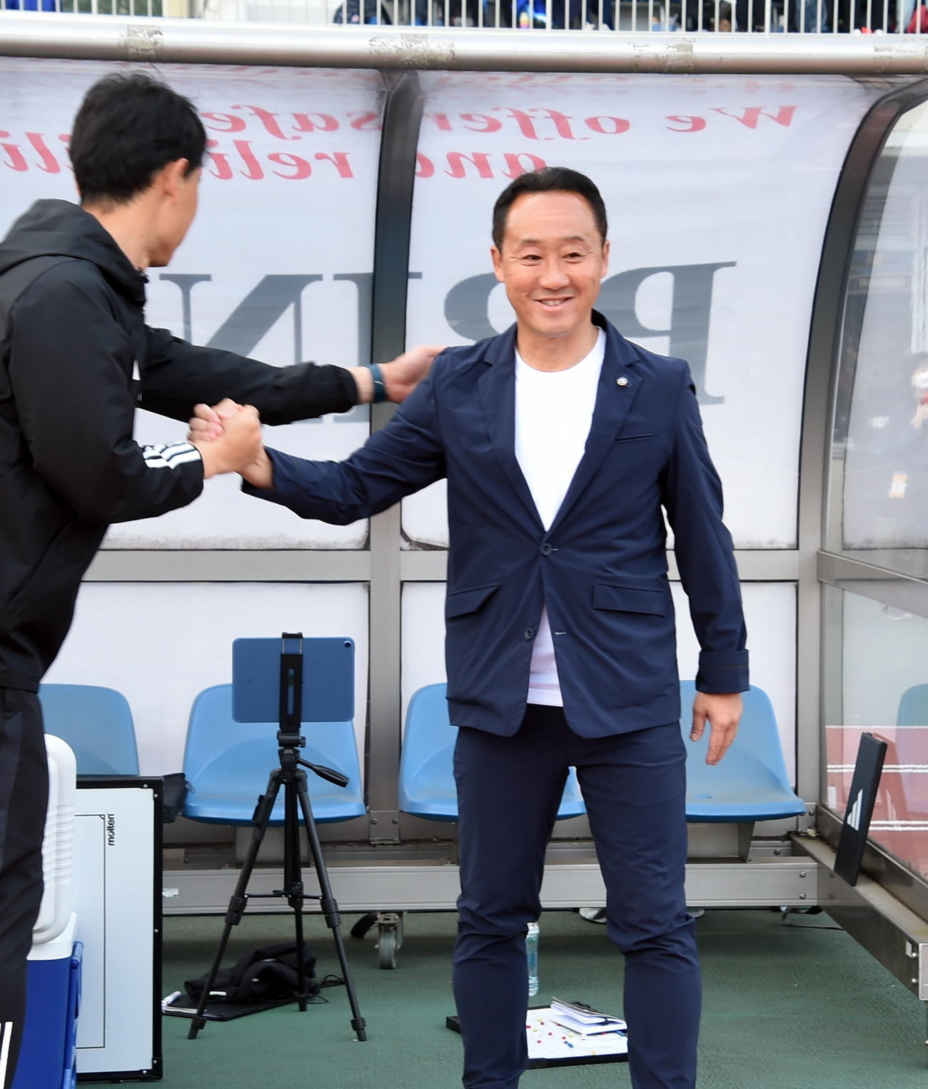 町田対仙台　試合前にコーチと握手する町田・黒田監督（右）（撮影・山田愛斗）