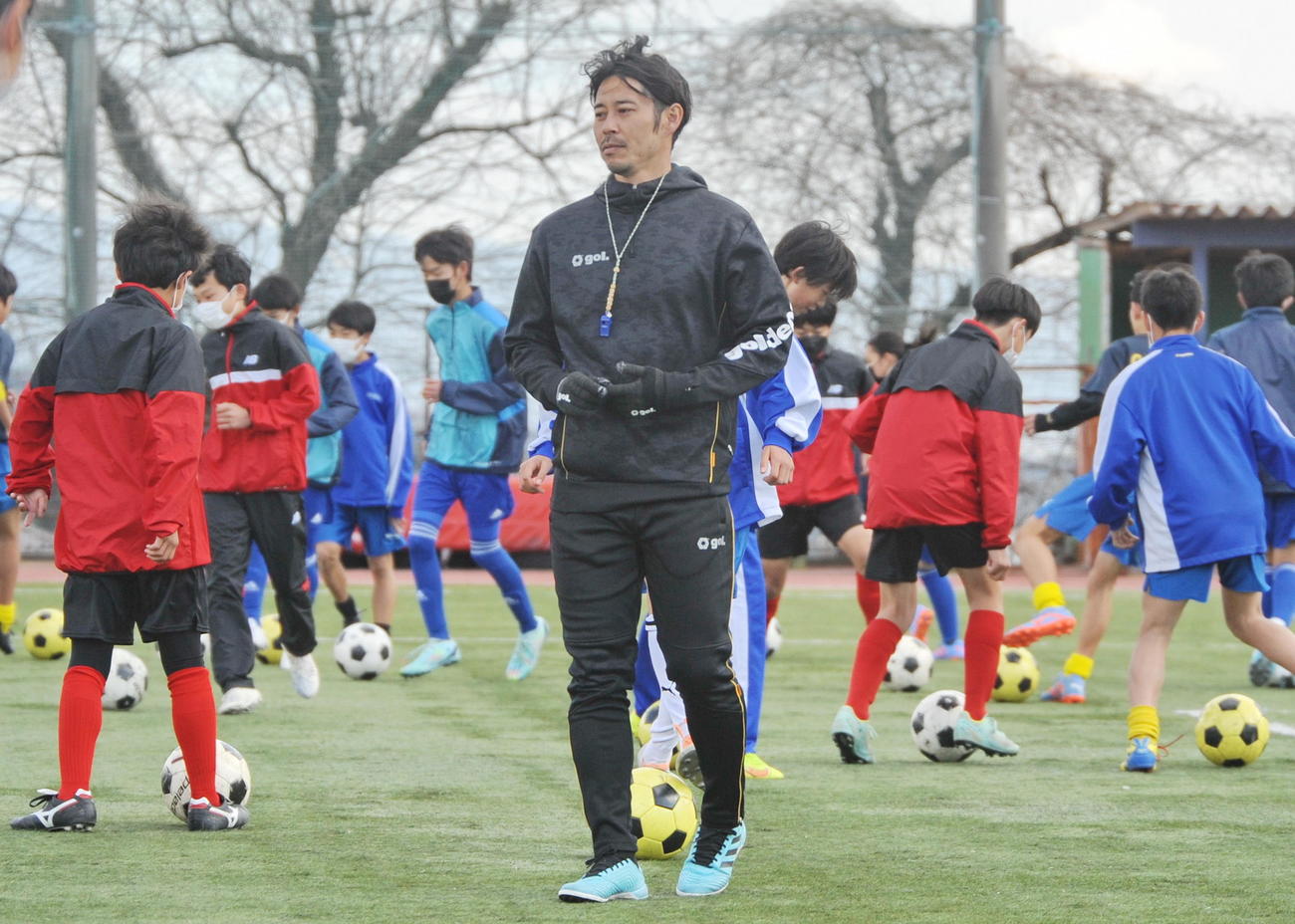 ドリブル練習を熱心に指導する成岡氏（中央）